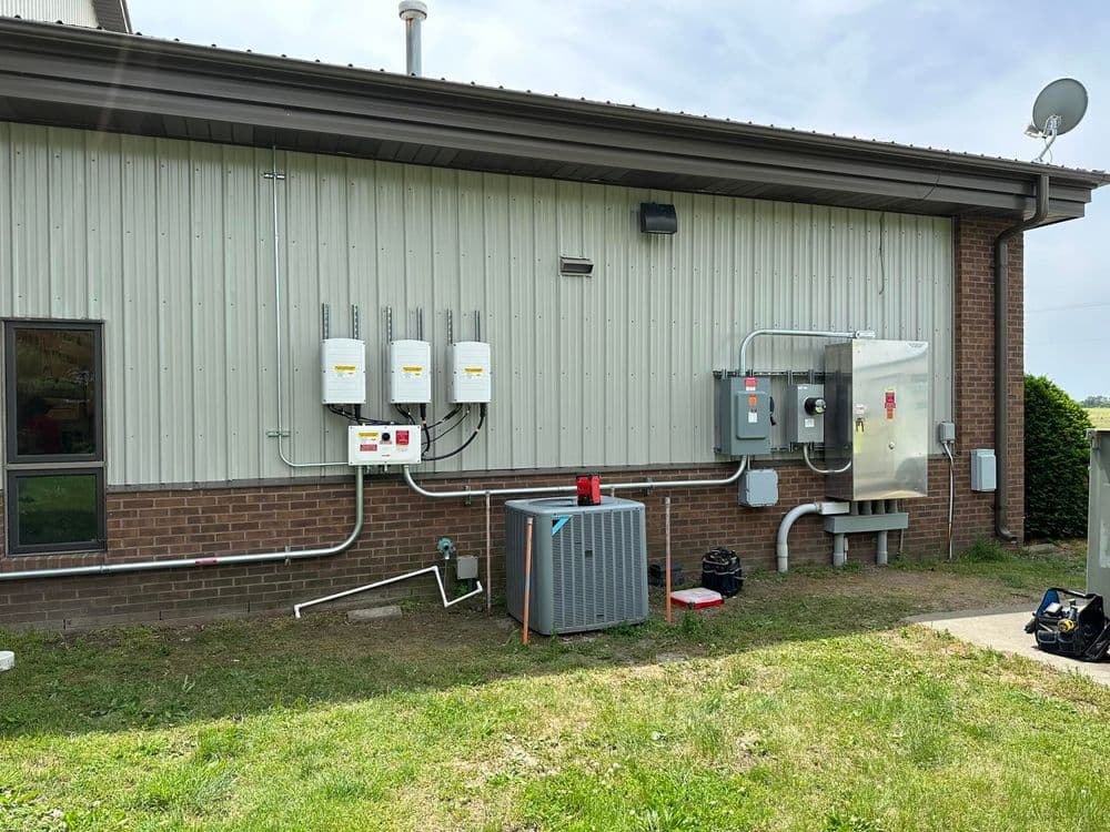Utility connection on a building exterior with HVAC unit and satellite dish.